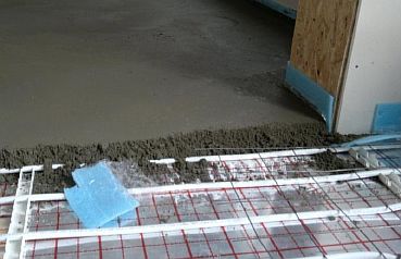 Foto - Hældning af betonbelægning på gulvvarmeledningen