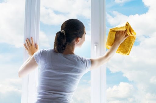 billede af en kvinde, der vasker et vindue