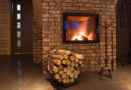 Imaginea arată un șemineu cu încălzire, cu așezarea lemnului de foc