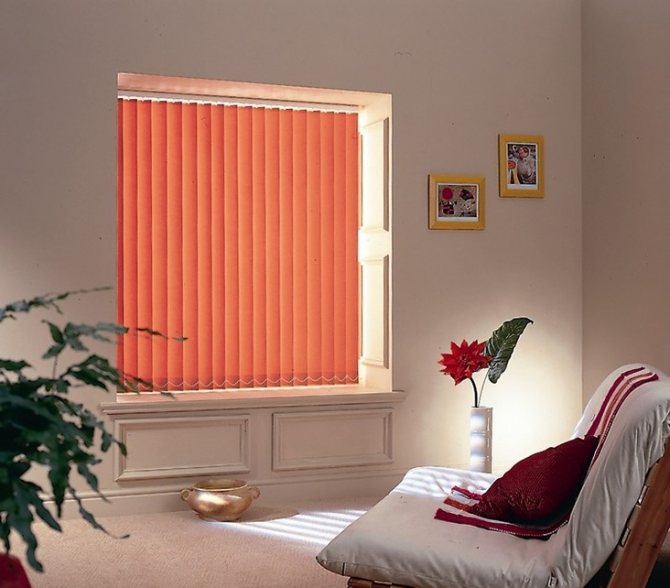 Ang mga orange blinds sa isang maliit na larawan sa bintana