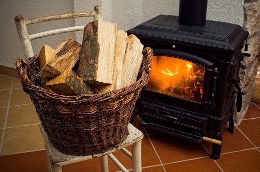 Un coș de răchită folosit ca stivă pentru păstrarea lemnului de foc arată foarte colorat