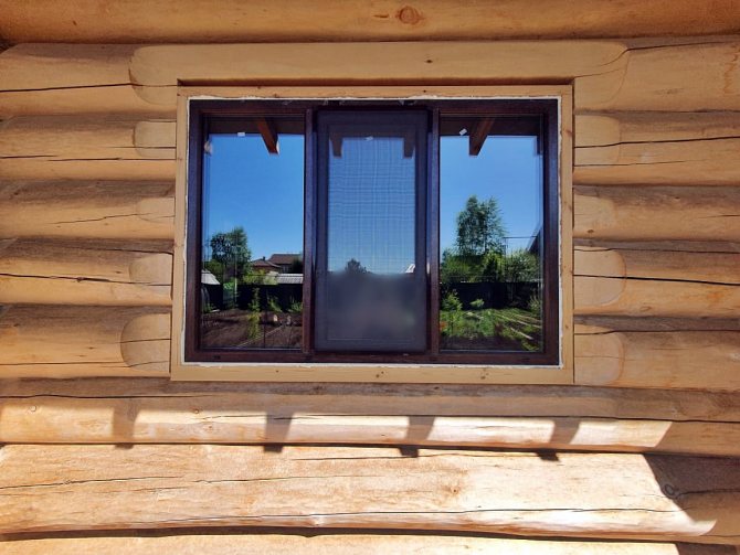 Deschiderea ferestrei într-o casă de bușteni sub o fereastră din plastic - vedere exterioară